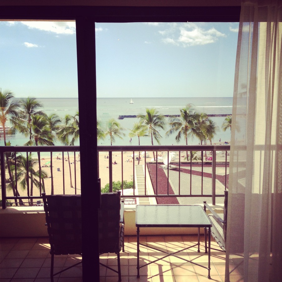 a balcony with a view of the beach and palm trees