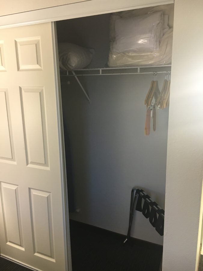 Closet with rack, hangers, extra pillows & blankets