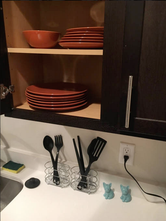 a kitchen cabinet with plates and utensils