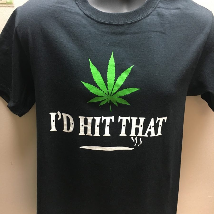 a black shirt with a green leaf on it