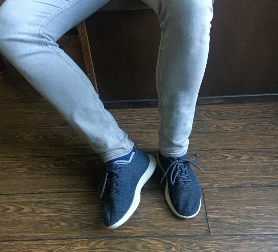 a person's legs and feet wearing blue shoes