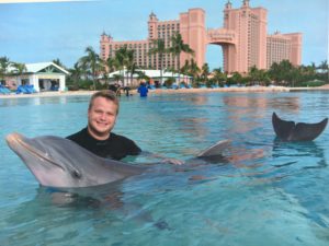 a man in a pool with two dolphins
