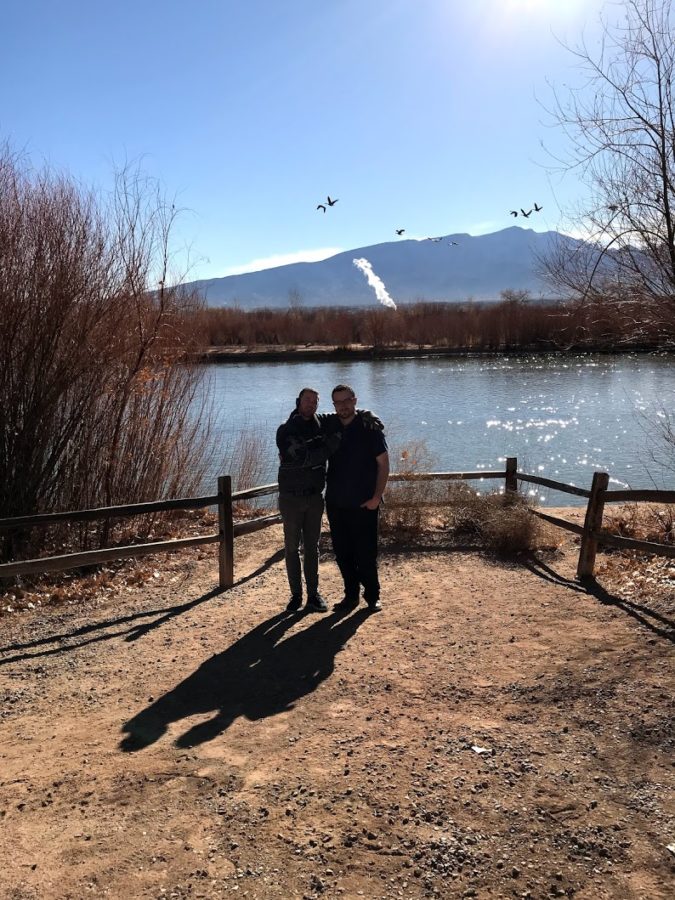 a couple standing on a path by a lake