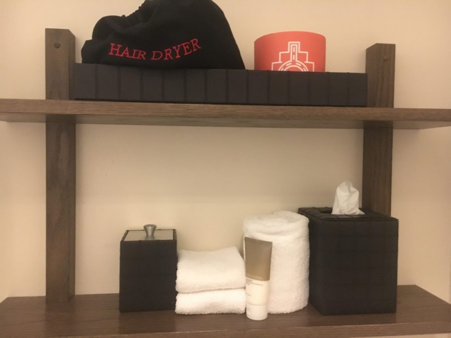 a shelf with a black and white towel and a black hat on top