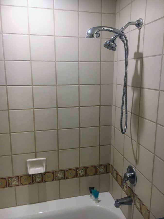 a shower head and a tile wall