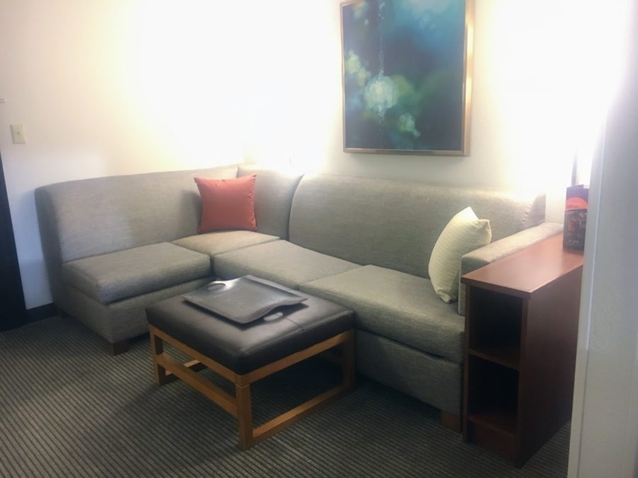 a couch with a table and a painting on the wall