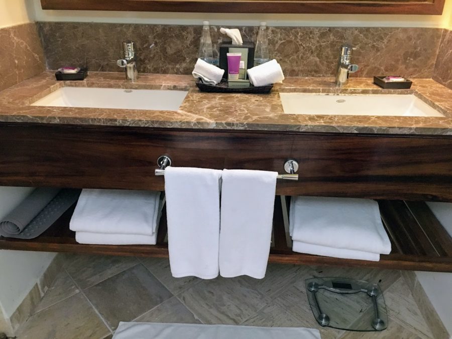 a bathroom with marble counter top and marble countertop