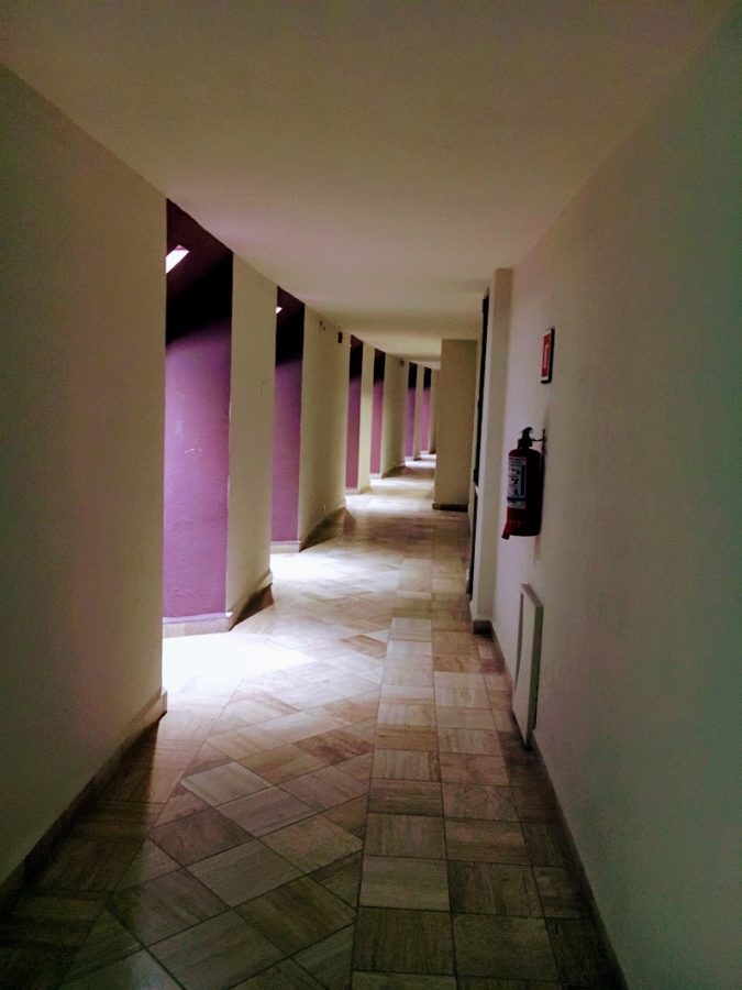 a hallway with white pillars and purple walls