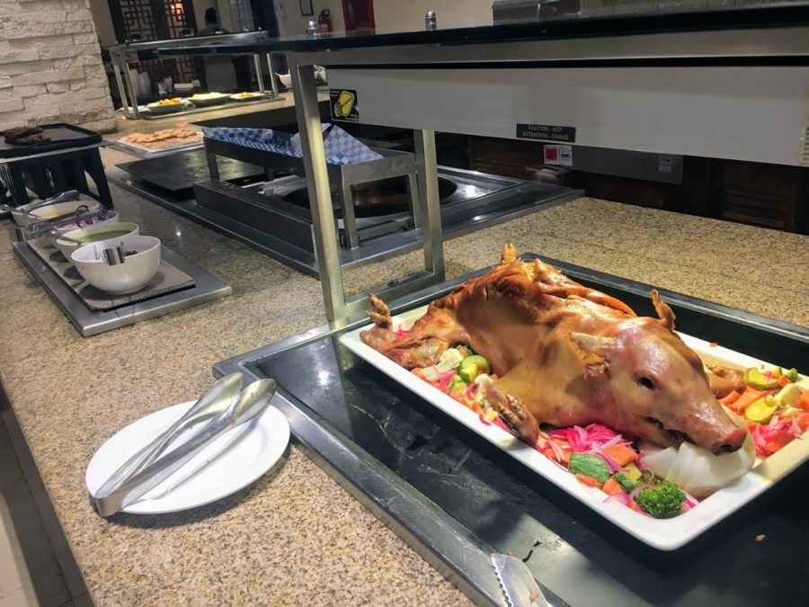 a pig on a tray with vegetables on it
