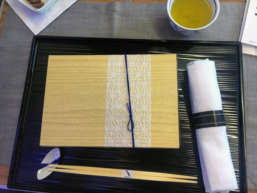 a tray with chopsticks and a plate with a napkin and a cup of tea