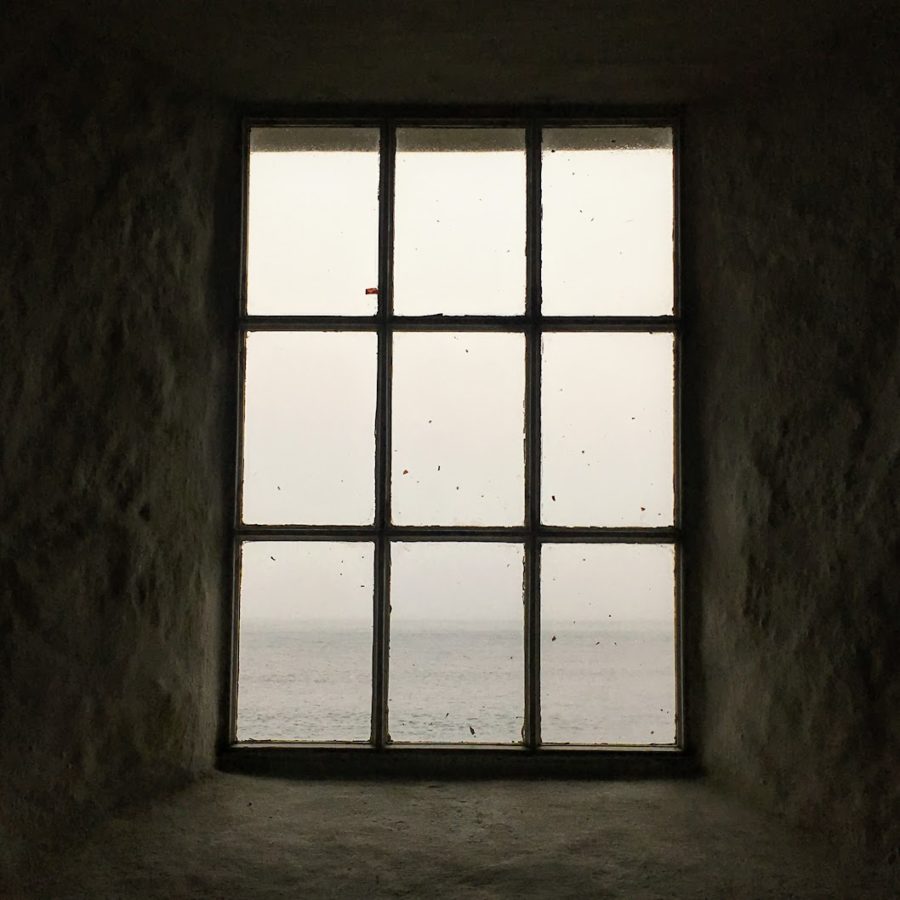 a window in a room with water in the background