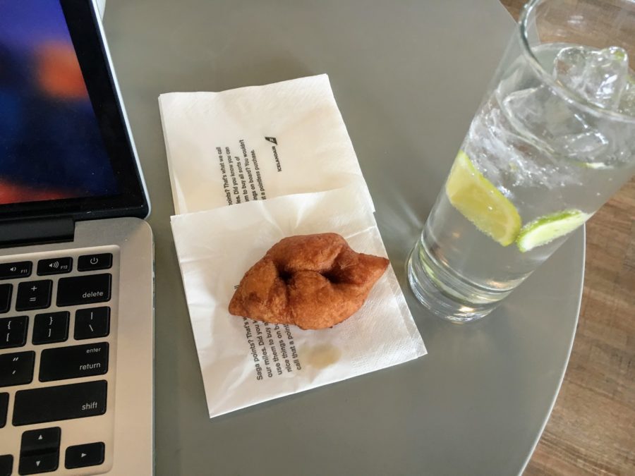 a donut on a napkin next to a glass of water