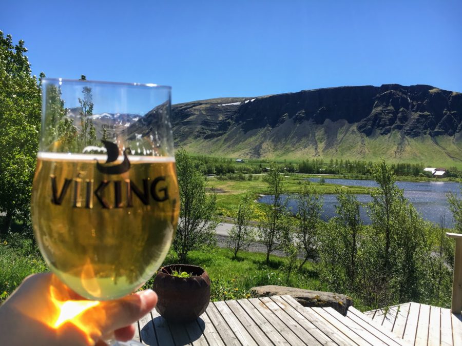 a hand holding a glass of wine with a mountain in the background