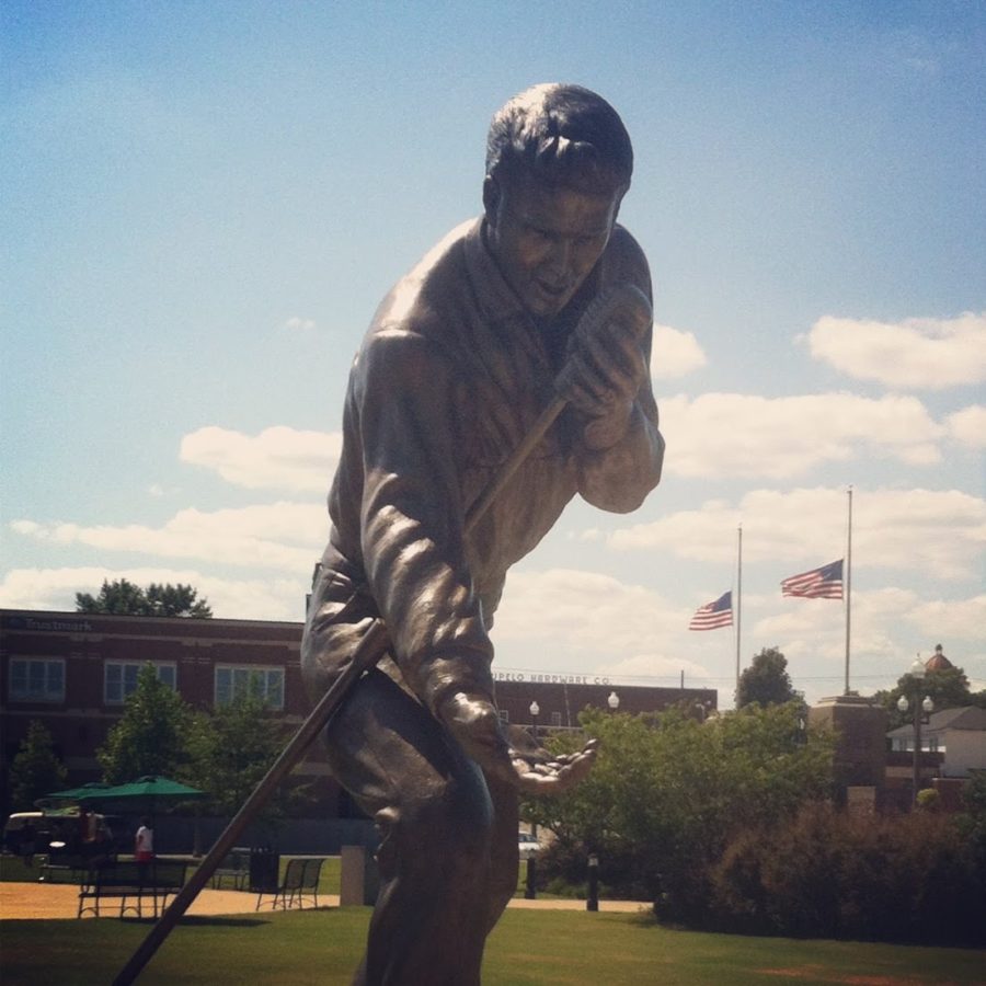 a statue of a man holding a golf club