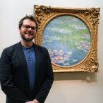 a man standing in front of a painting