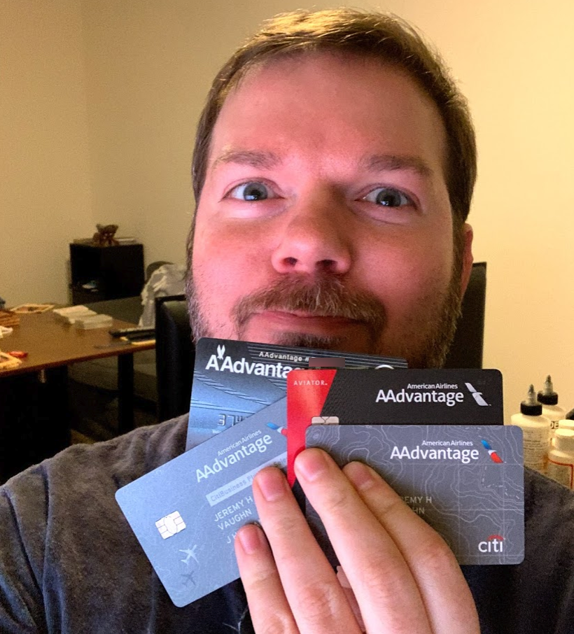 a man holding up some credit cards