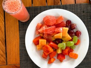 a plate of fruit and a glass of juice