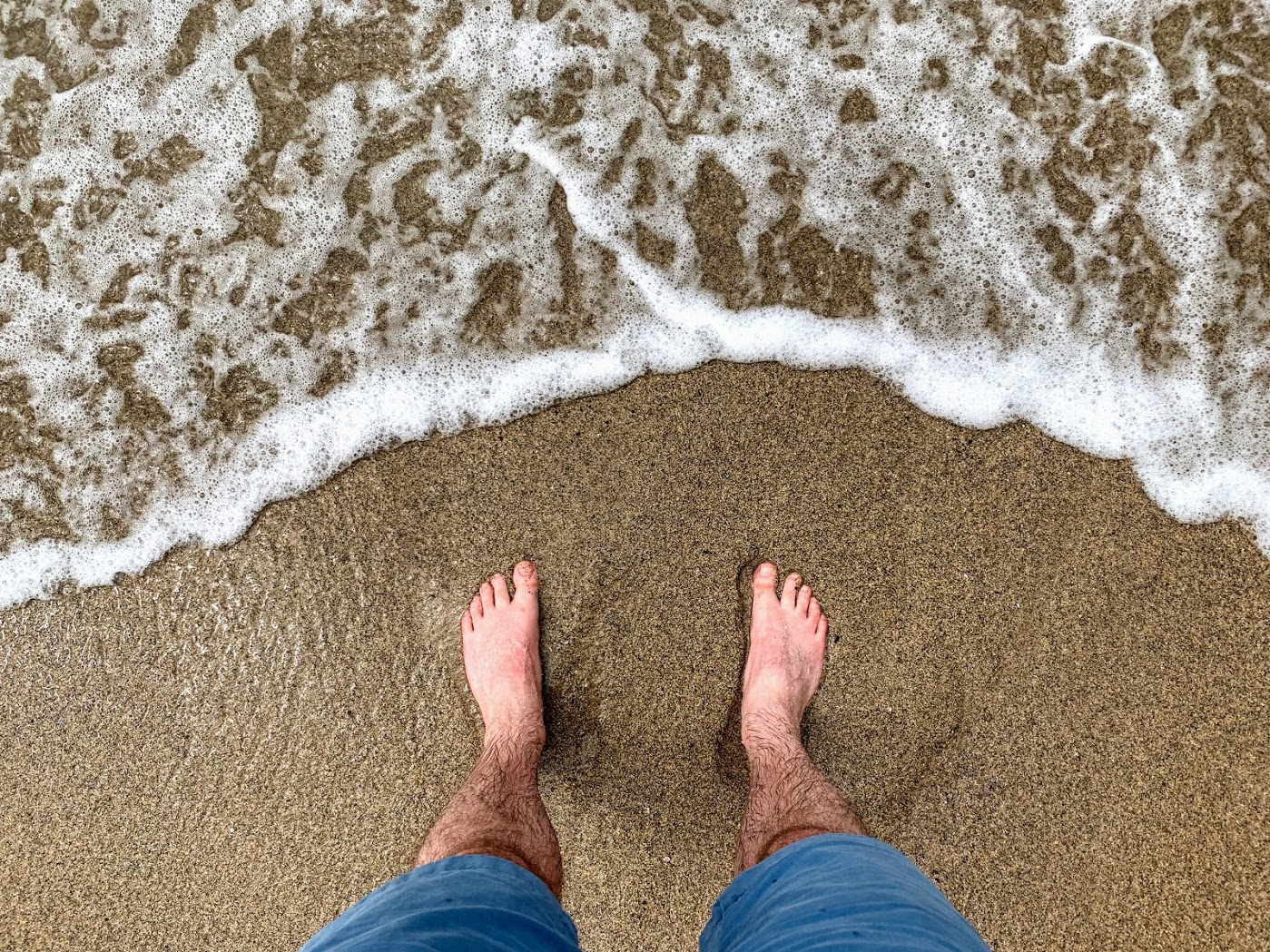 a person's feet on a beach