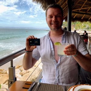a man holding a drink and a camera