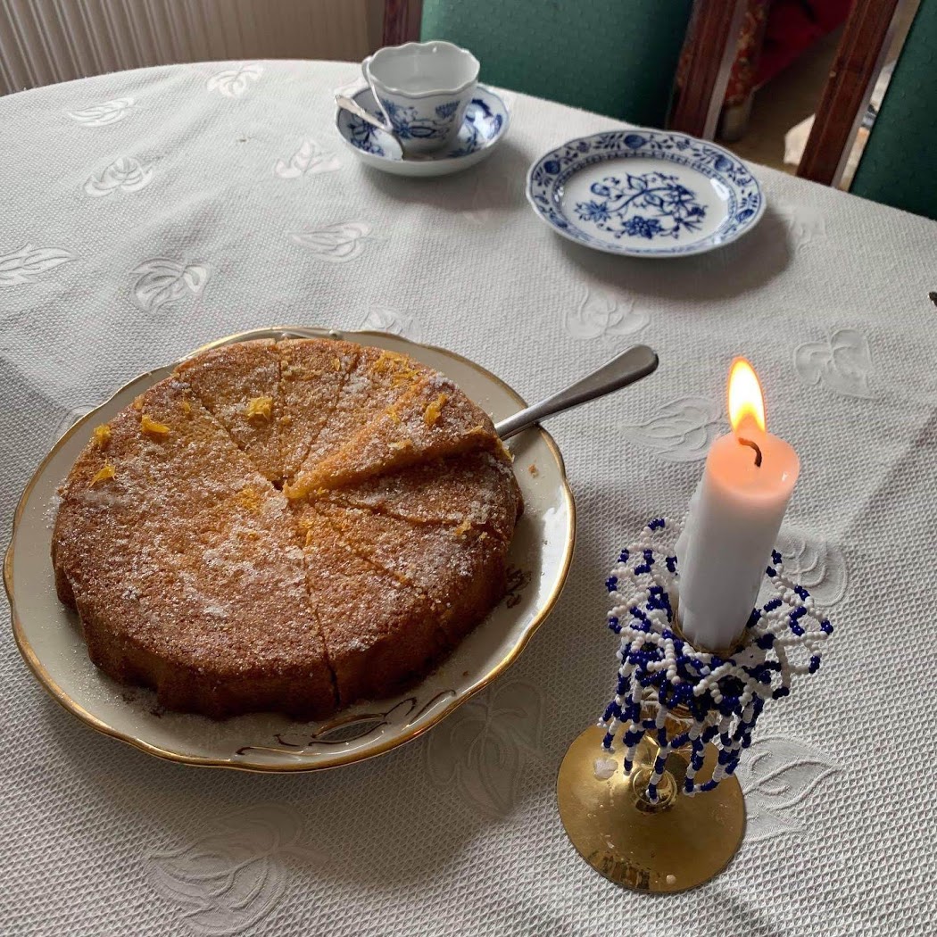a cake on a plate next to a candle