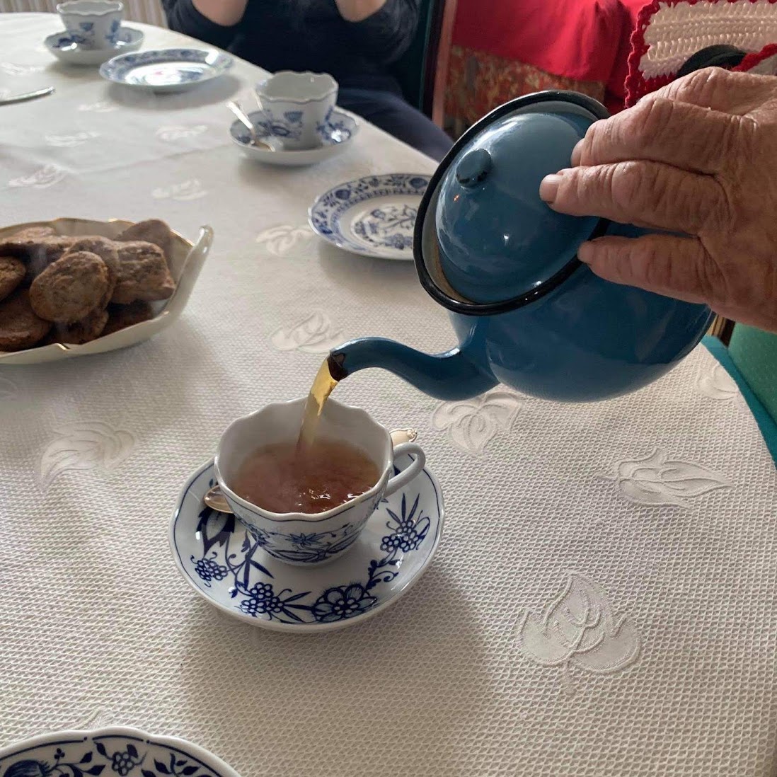 a person pouring tea into a cup