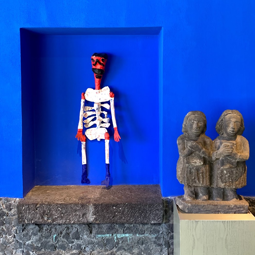 a statue of a skeleton in a blue wall