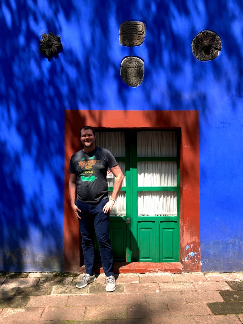 a man standing in front of a blue building
