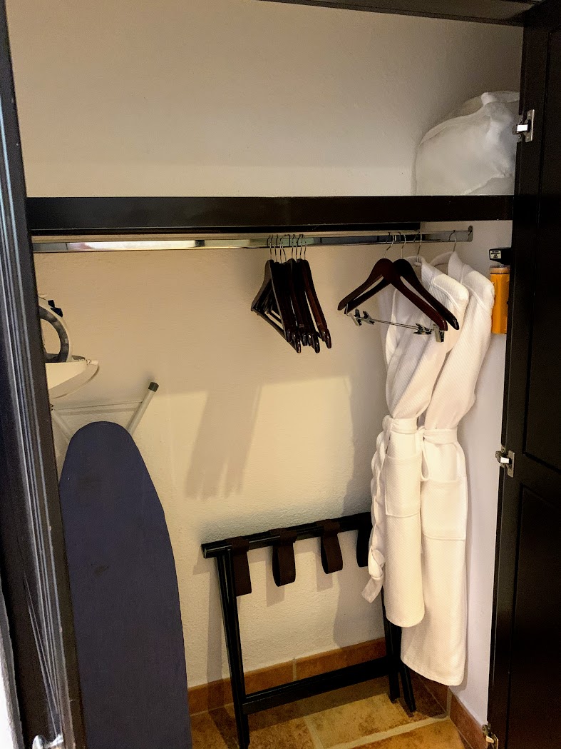 a closet with white robe and swingers