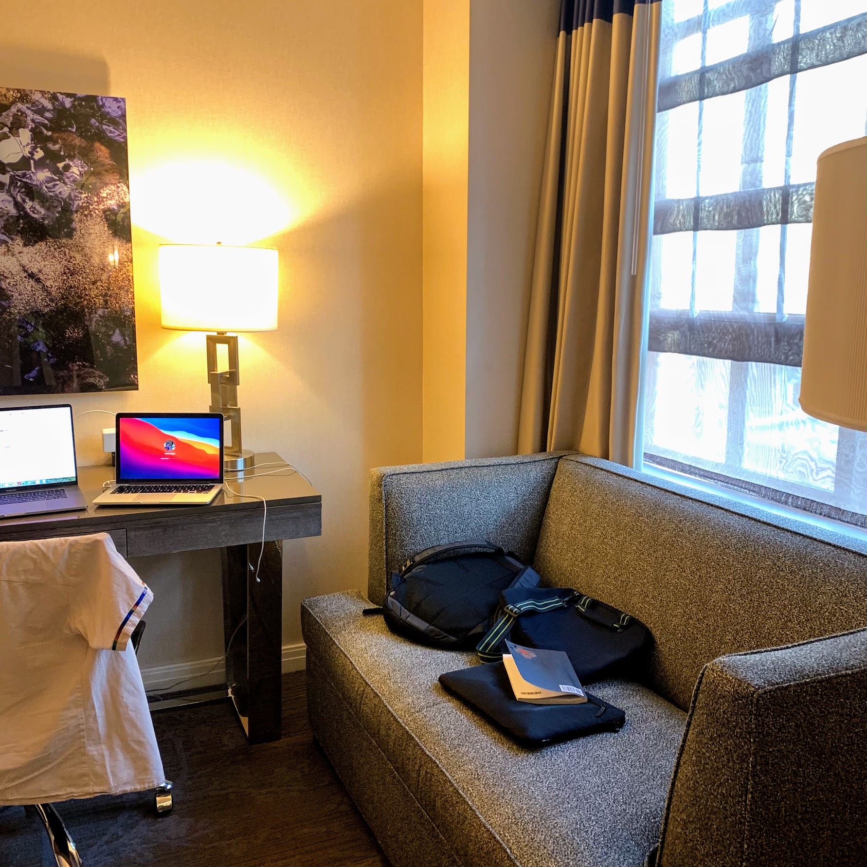 a couch with a laptop and a lamp in a room