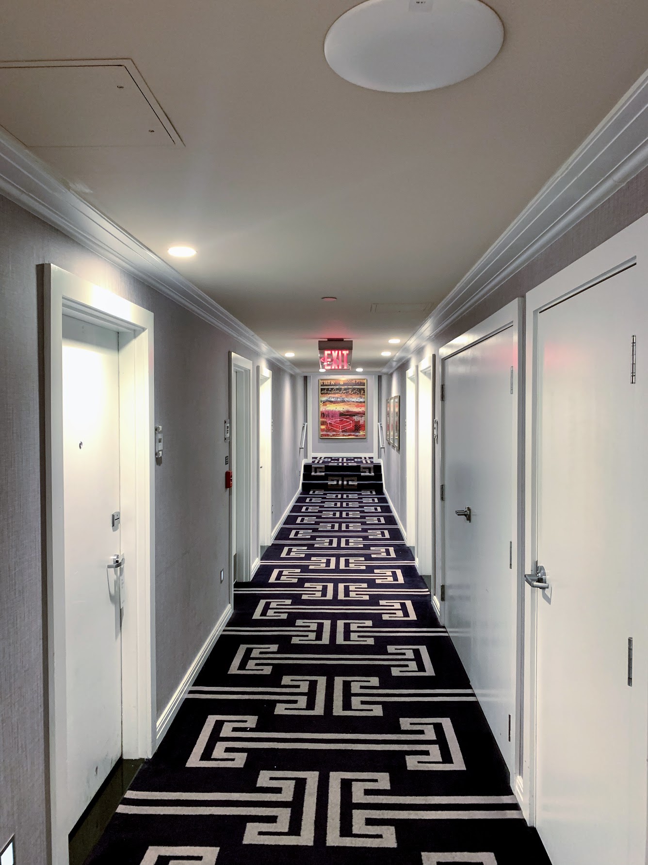 a hallway with doors and a carpet