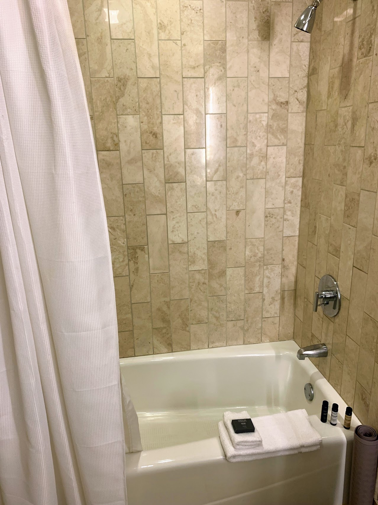 a bathtub with towels and a shower curtain