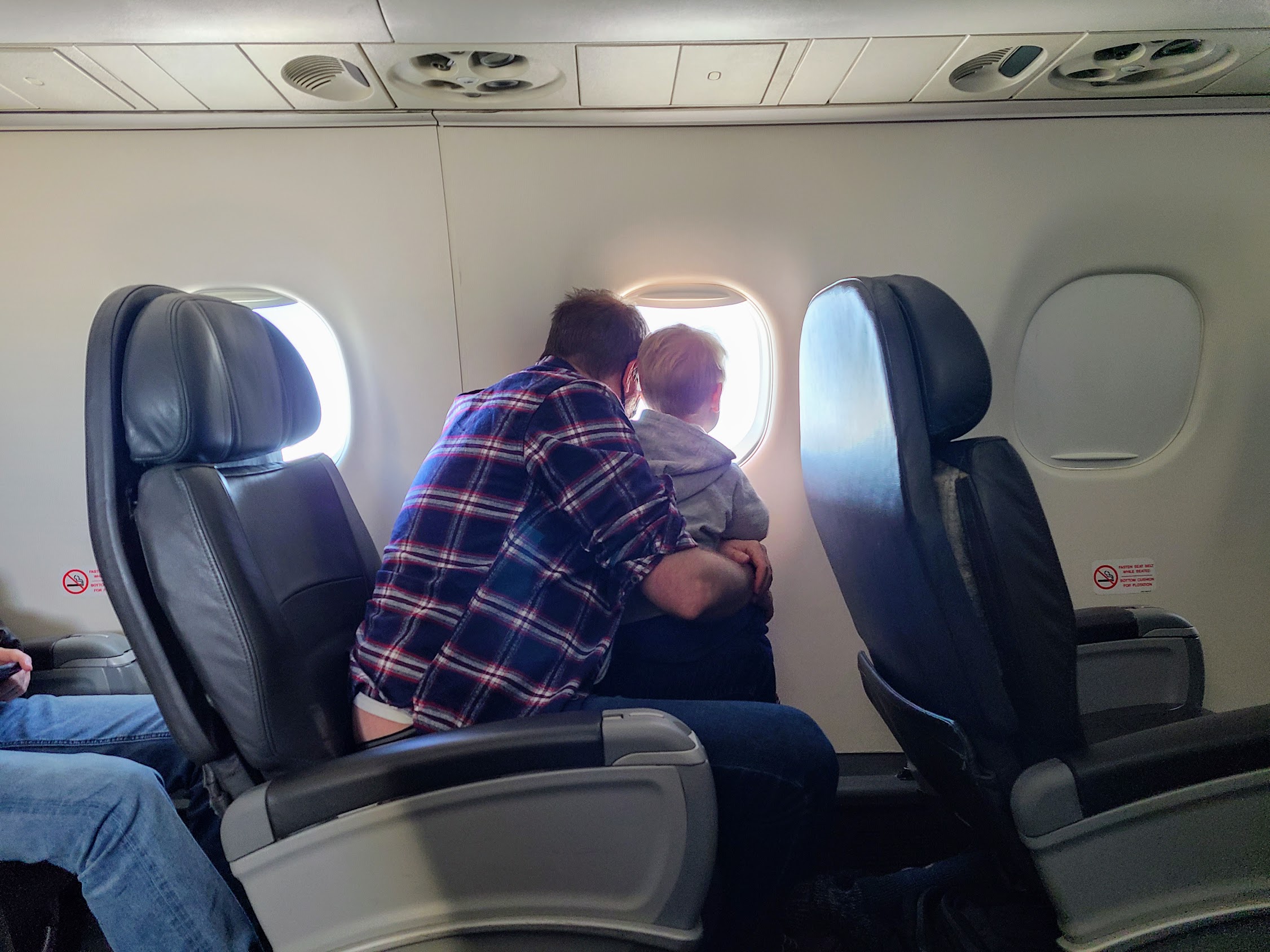 a man and child sitting in an airplane