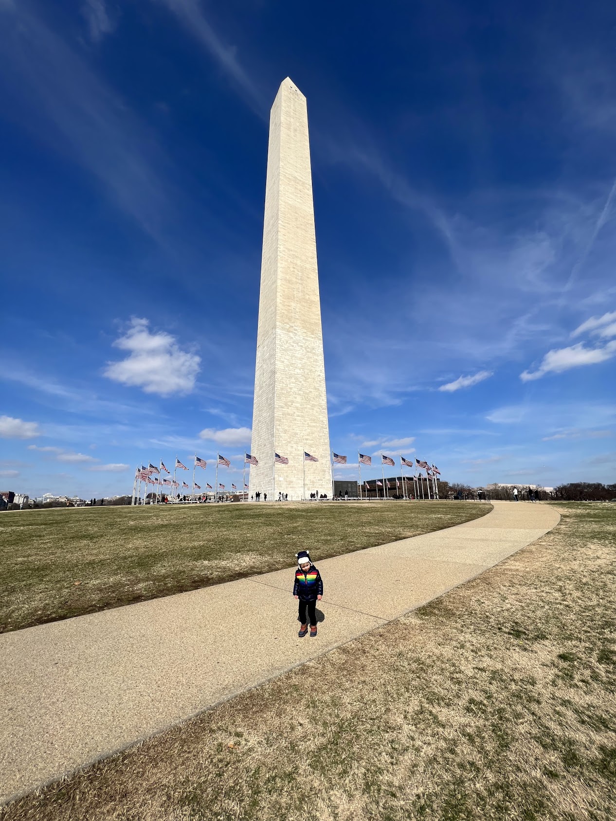 a child standing in front of a tall monument