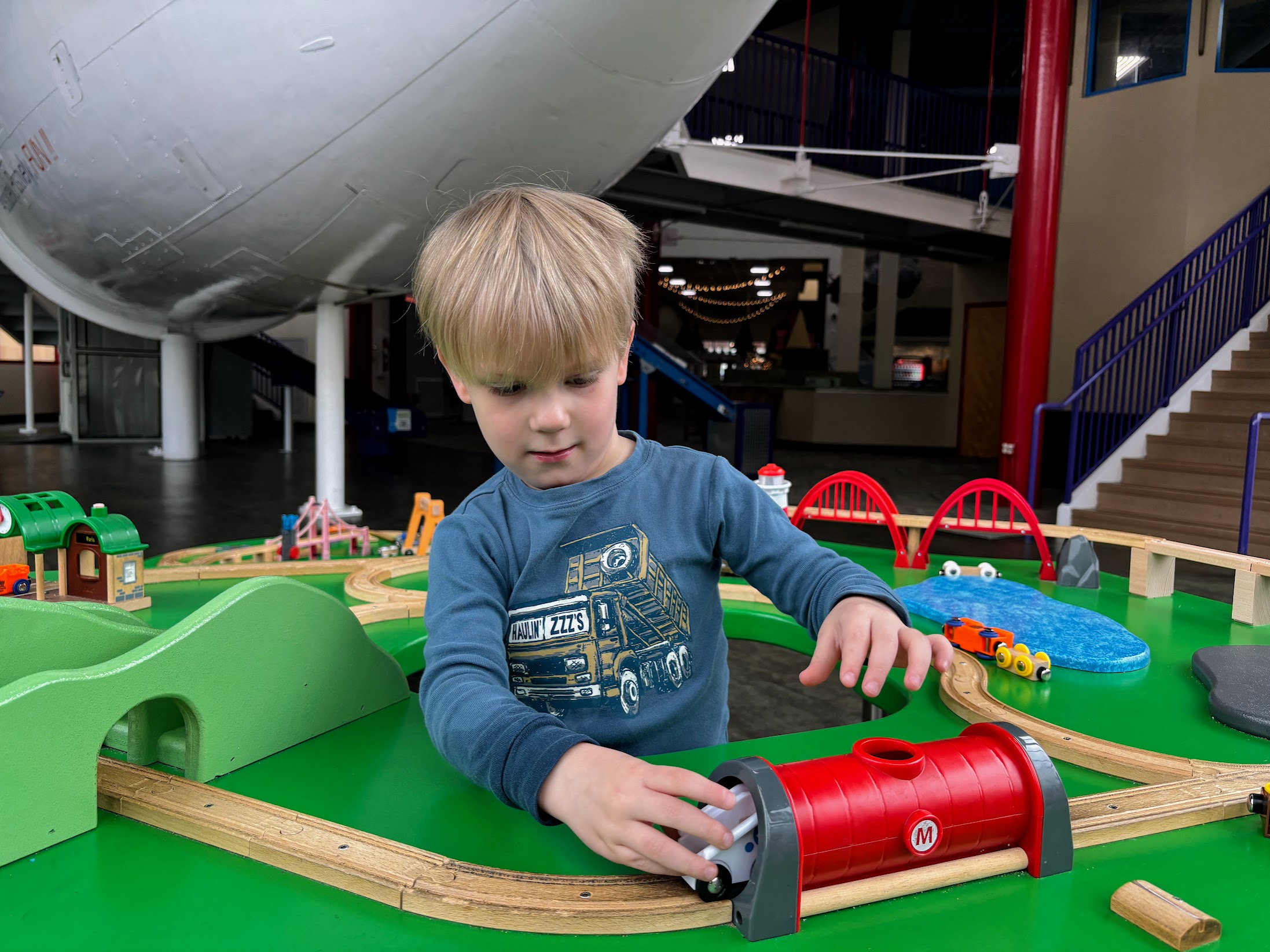 a boy playing with a toy train