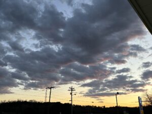 a cloudy sky with power lines and telephone poles