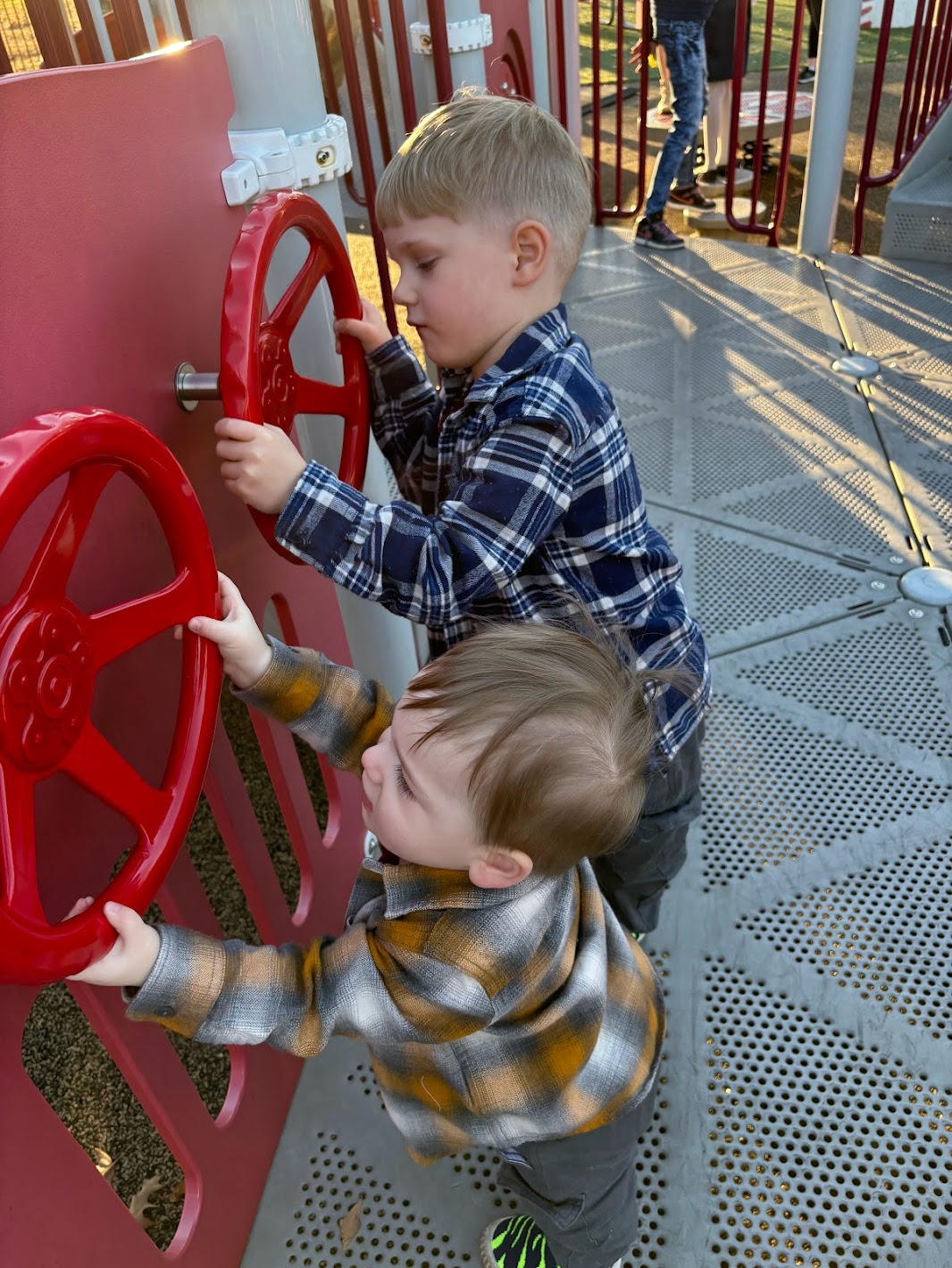 two boys playing with red wheels