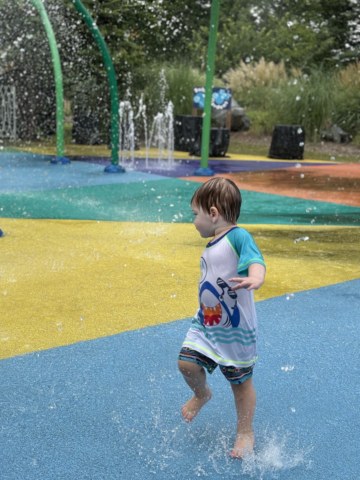 a child playing in water at a park