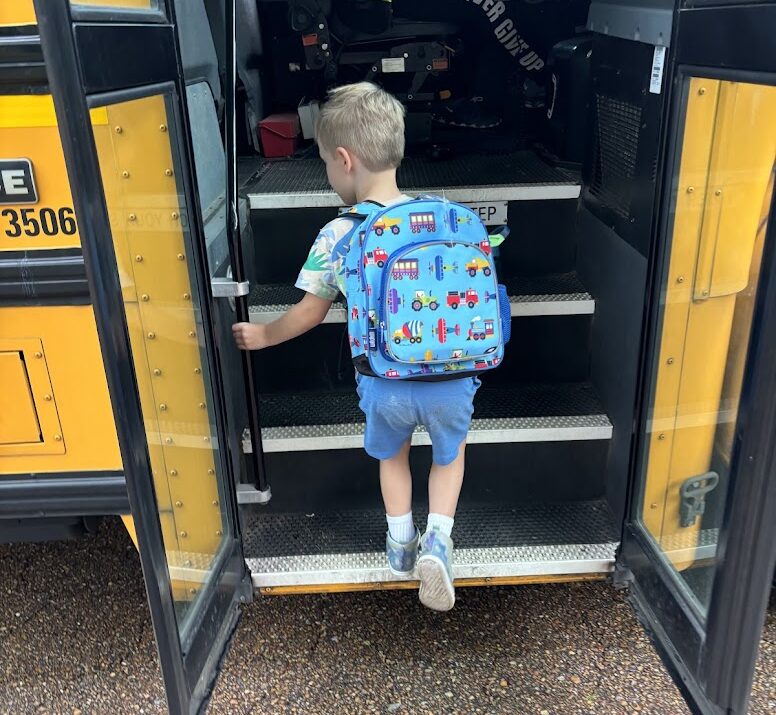 a child climbing up the stairs of a school bus