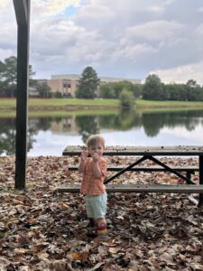 a child standing on a bench near a lake