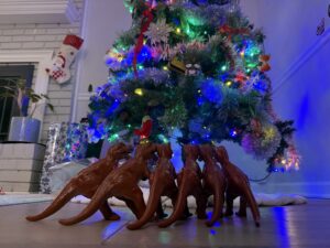 a group of dinosaurs next to a christmas tree