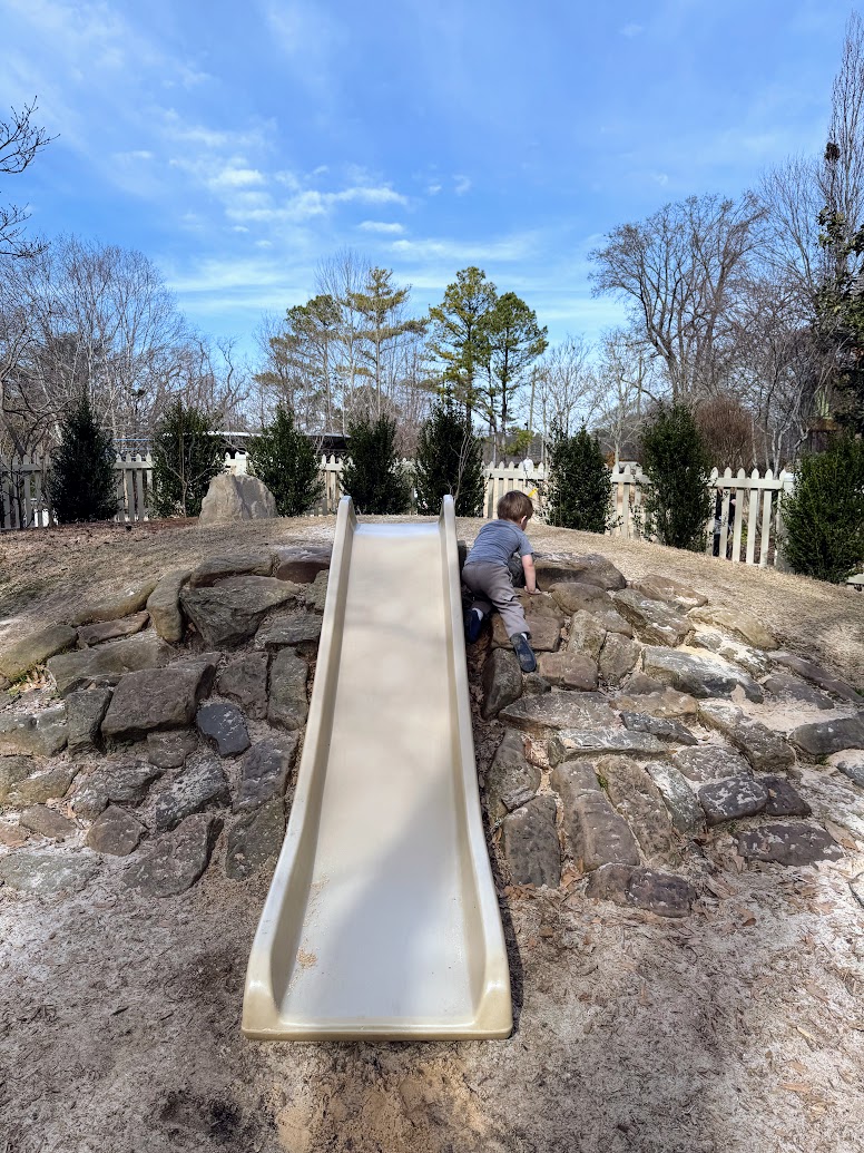 a boy playing on a slide