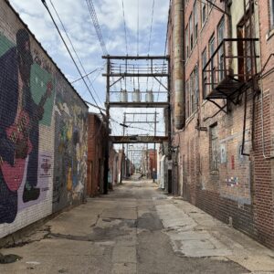a brick alley way with graffiti on the side